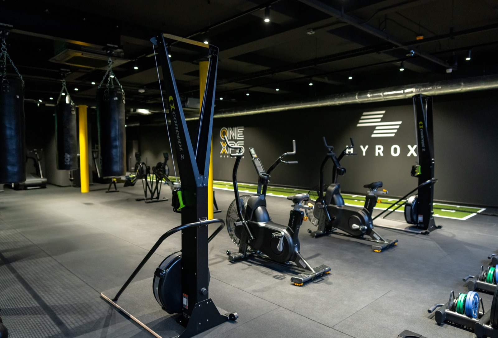 Cardio and conditioning zone with ski-ergs, assault bikes, and punch bags at the Full Motion Physio Manchester gym