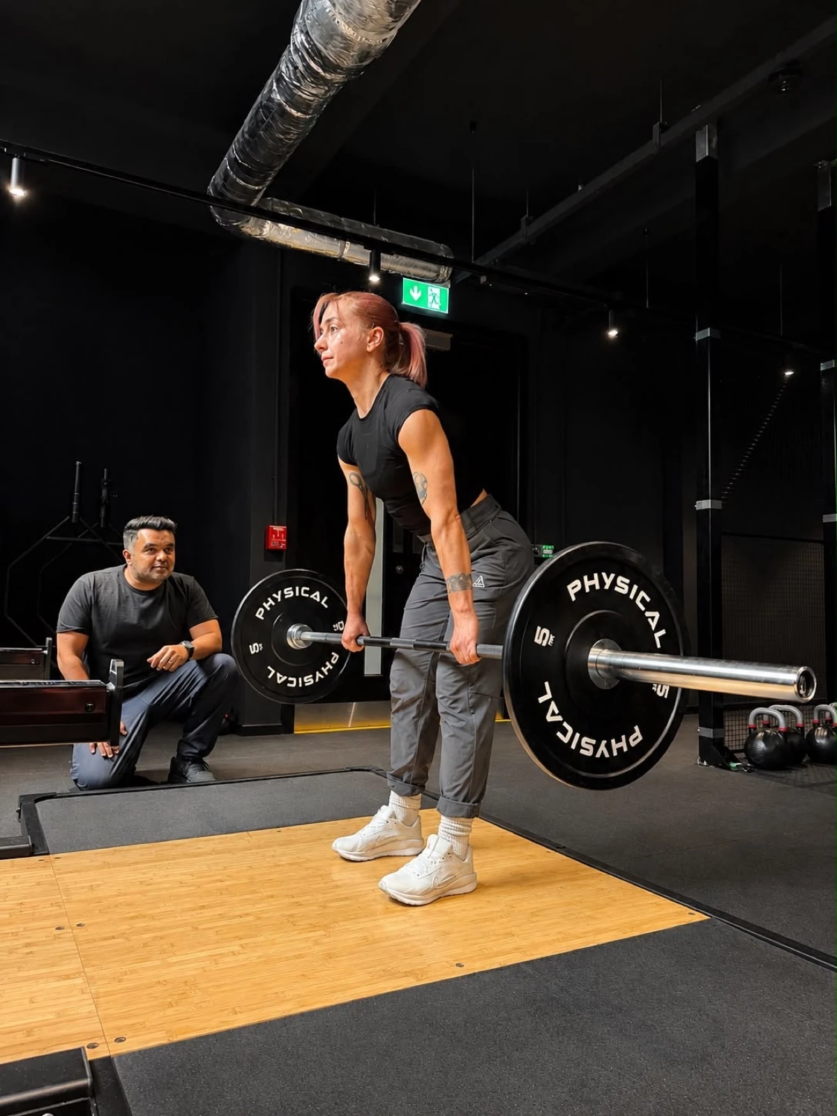 Physiotherapist supervising a barbell deadlift in the gym at Full Motion Physio Manchester