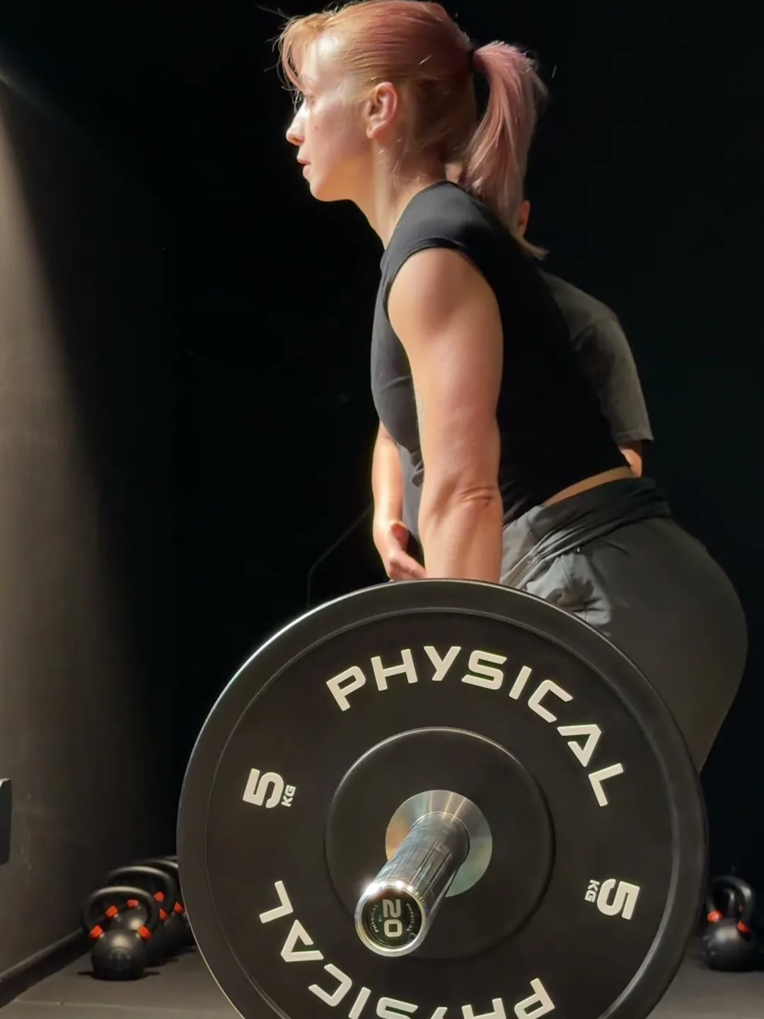 Athlete locking out a barbell deadlift in the performance gym at Full Motion Physio Manchester
