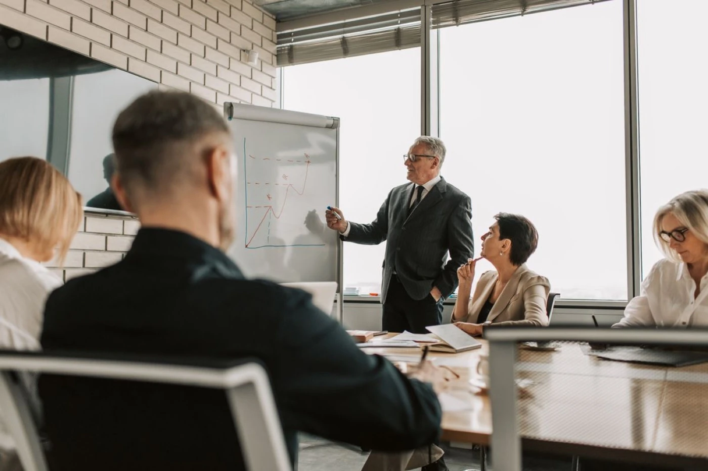 A professional chairing a meeting in a boardroom, a high-demand professional voice user