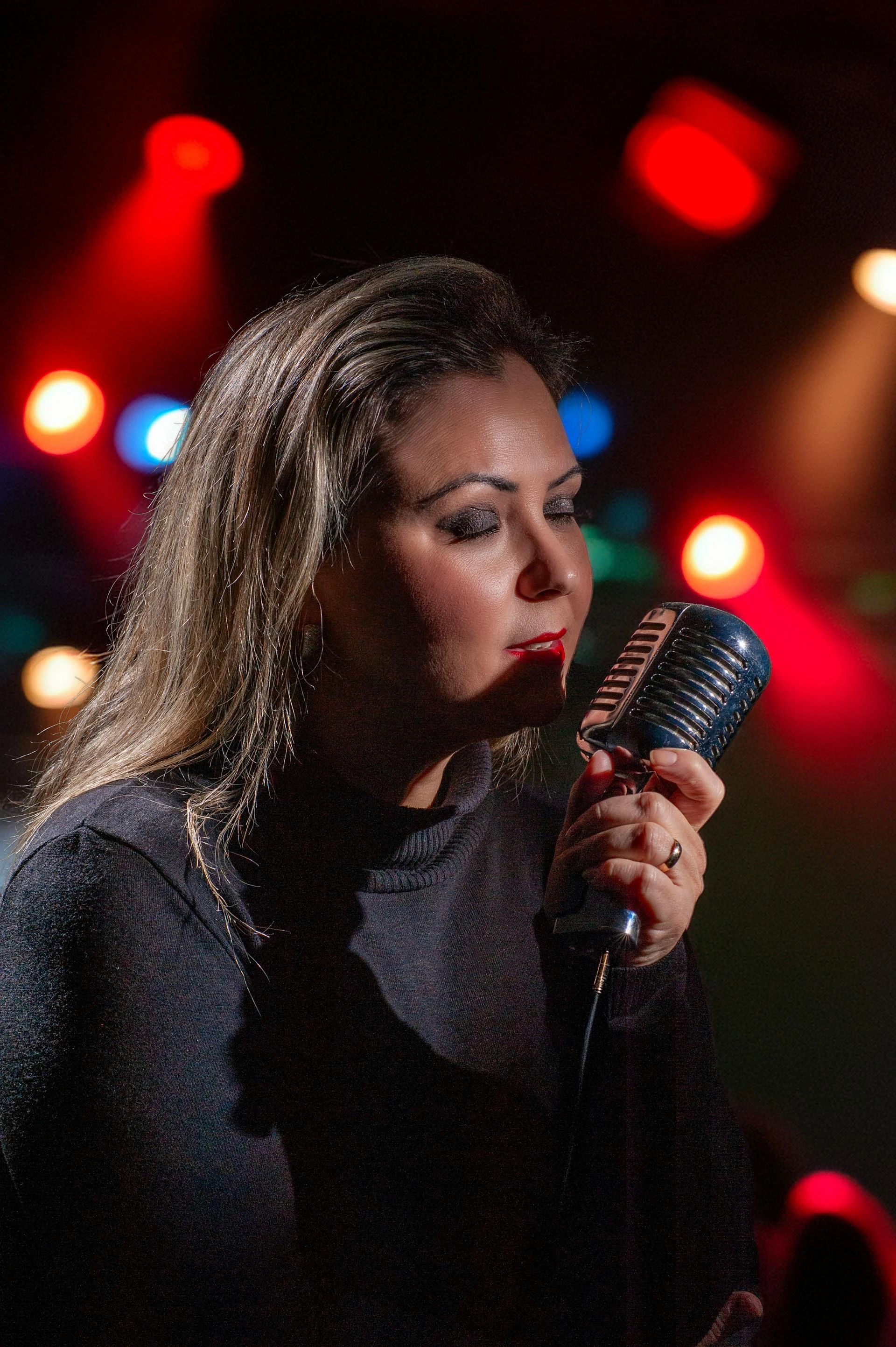 Singer performing into a microphone, a heavy voice user vocal massage supports